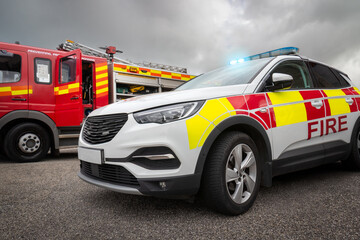 Fire truck and car emergency services vehicles. The fire engines carry ladders, firefighting...
