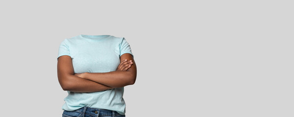 A headless person stands confidently with arms crossed, showcasing a casual blue shirt. The...