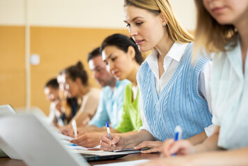 Small group of students attentively listening to lecture in university classroom