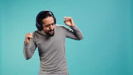 Happy person having fun, dancing on rhythm, listening music on headphones, enjoying leisure time....