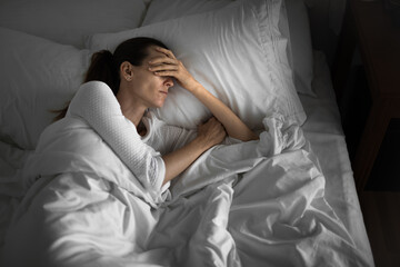 sad depressed tired woman home alone in her bed getting bad sleep  