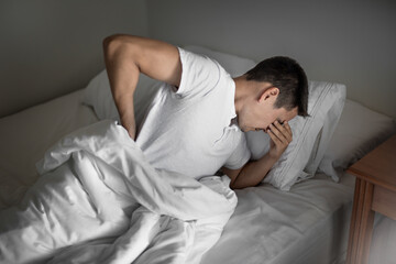 Man waking up suffering from back ache pain getting bad sleep 
