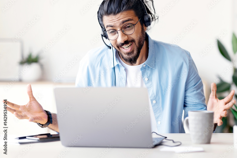 Poster joyful arab man in headset having web conference on laptop in office, cheerful eastern guy making vi