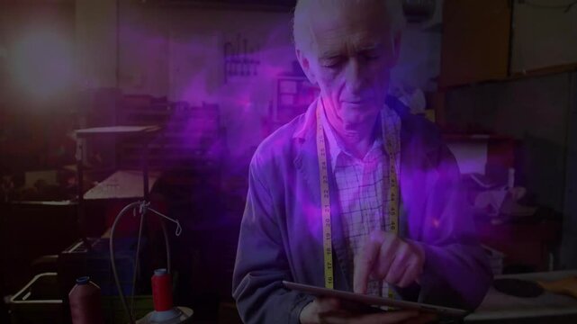senior tailor tapping tablet in fashion tech workshop, projecting fabric chart, showing purple glow