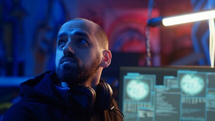 Hacker hiding in underground bunker, looking over his shoulder and feeling anxious after stealing...