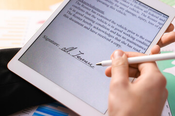 Electronic signature. Man using stylus and tablet at table, closeup