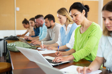 Fototapeta premium Group adult students listening and writing during business course