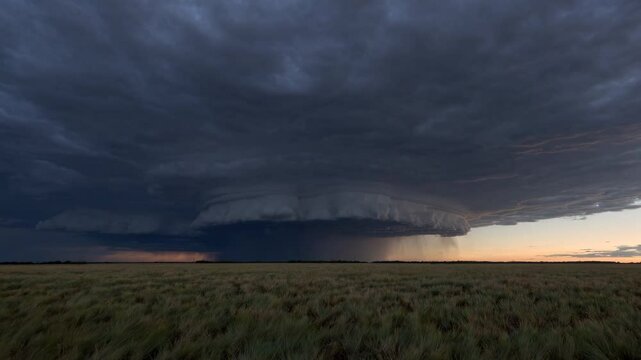 Dramatic storm clouds rolling over prairie at sunset captured in timelapse sequence