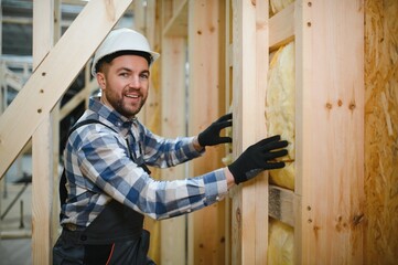 Modern modular house. A worker works on the construction of a wooden house
