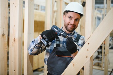 Worker carpenter assembling a modular house