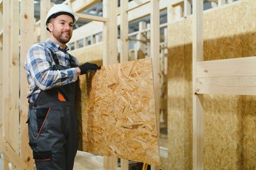 Portrait of a carpenter smiling with crossed arms in a lumber warehouse, showcasing expertise in...