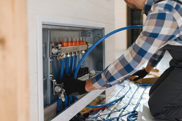Service man instelling house heating system under the floor