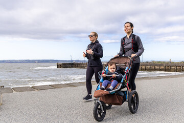 Women Jogging with Child on West Vancouver Centennial Seawalk in Sunny Weather