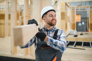 Modern modular house. A worker works on the construction of a wooden house