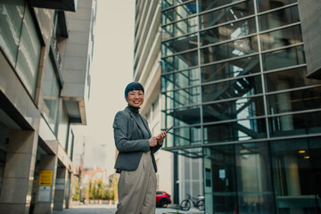 Smiling businesswoman holding tablet in modern city setting
