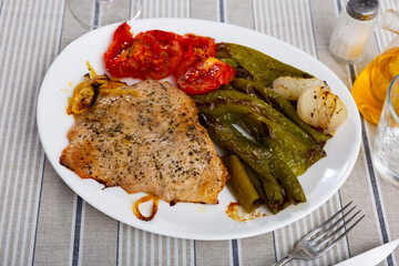 Spanish Secreto de cerdo - roasted pork served with stewed pepper and tomatoes