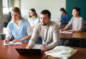 University students exercising in class room during lesson.