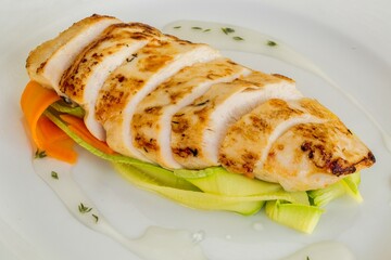 Slices of Grilled Chicken Fillet, Decorated with Vegetables and Sauce on White Plate, Representing Healthy and Balanced Eating.
