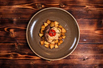 Juicy grilled chicken fillet with potatoes, sauce, and fresh salad. Top view, dark wooden background.
