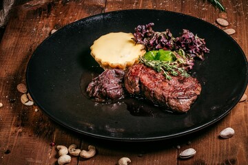 Beef steak with cheesy side and greens, macro shot