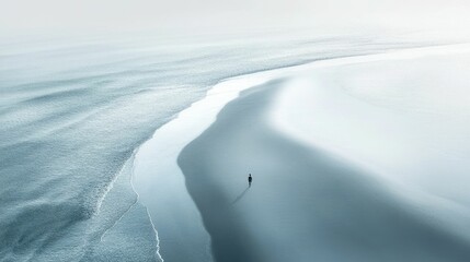 A solitary figure walks a pristine beach, where the ocean's gentle waves meet the shore.
