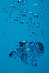 Many water bubbles on blue background, closeup