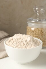 Brown rice and flour on white table. Space for text