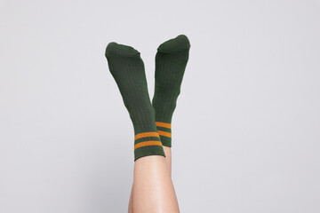 Woman in stylish socks on light grey background, closeup