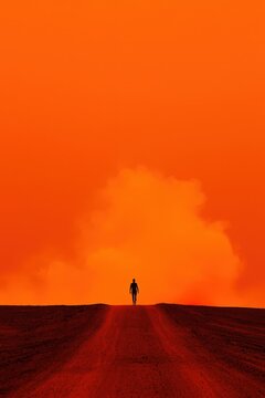 A man is walking on a dirt road in the desert
