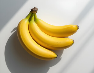 A group of 3 fresh yellow and green banana arranged closely together on a clean white background