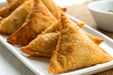 Golden and crispy Indian deep-fried samosa on white plate