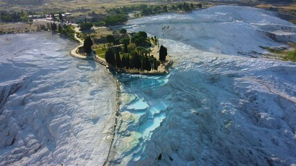 Travertines of Pamukkale top view - Denizli, Turkey. Natural pools. Cotton castle from a bird's-eye view. Hot blue springs forming limestone deposits of travertine.Drone.4K