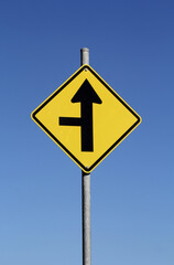 Side Road Intersection road sign against a clear blue sky background
