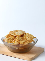 melinjo chips snack in a glass bowl on a wooden board
