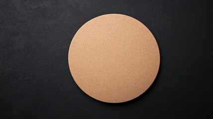 A simplistic, round cork board rests on a dark textured surface, highlighting its natural color and shape.