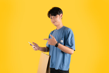 a man with brown shopping bag while holding a phone and pointing at it