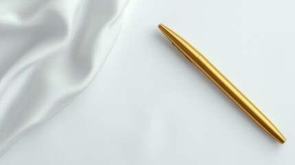 Naklejka premium A golden pen rests elegantly on a smooth white fabric, creating a refined and sophisticated visual contrast.