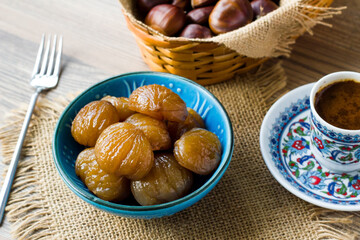 Traditional Turkish Candied Chestnuts designed in blue ceramic on wooden surface with coffee