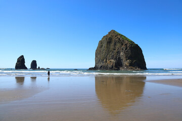 The iconic Haystack Rock on Cannon Beach in Oregon on a clear sunny day.