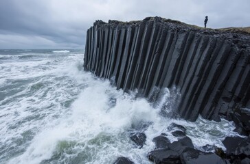 A lone traveler standing on a basalt column beach