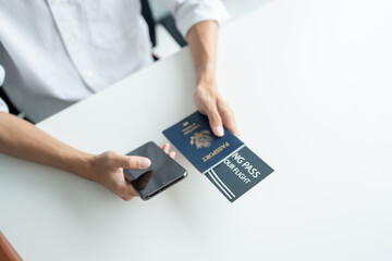 Hand Man Online booking and buying plane tickets using laptop phone and credit card Planning trip travel vacation with passport and ticket.