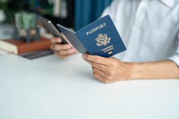 Hand Man Online booking and buying plane tickets using laptop phone and credit card Planning trip travel vacation with passport and ticket.