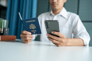 Hand Man Online booking and buying plane tickets using laptop phone and credit card Planning trip travel vacation with passport and ticket.
