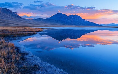 Serene mountain lake at sunset reflecting vibrant sky