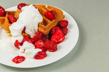 Delicious waffles topped with fresh strawberries and cream