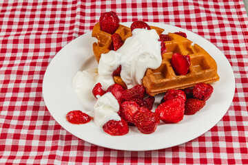Delicious waffles topped with strawberries and cream