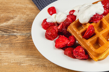 Delicious waffles topped with fresh strawberries and cream