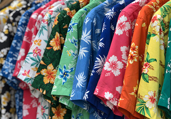 Colorful Hawaiian Shirts Floral Print Summer Clothes Displayed on a Rack. Vacation Attire Fashion.