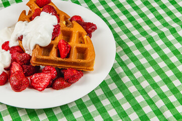 Delicious waffles topped with strawberries and cream