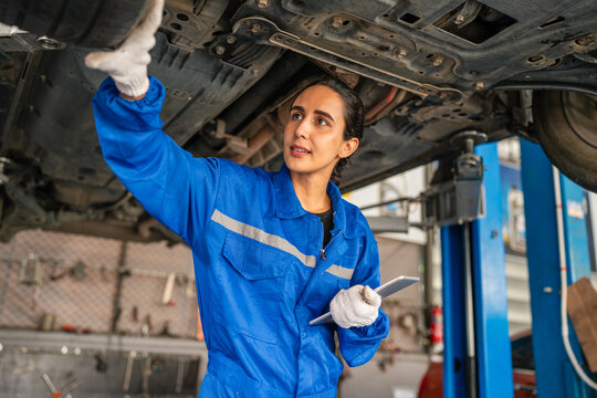 Female Auto mechanic are checking and repair maintenance auto engine.